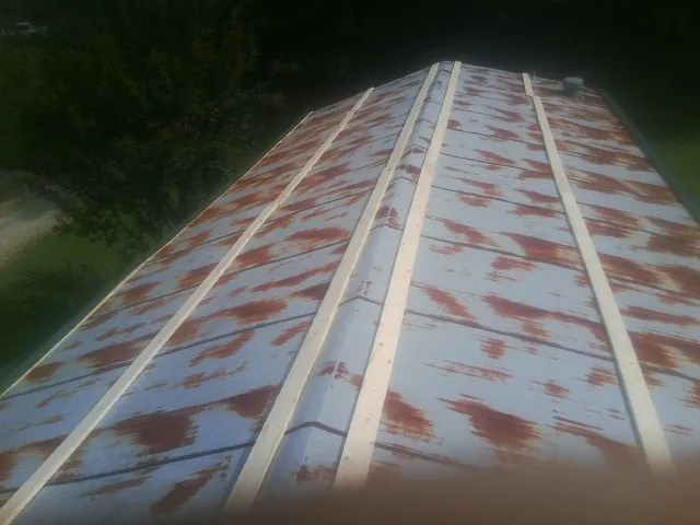 Rusted metal roof panels with new wood purlins before replacement — Storm Damage Roof Repair in Auburntown by Roofing Brothers