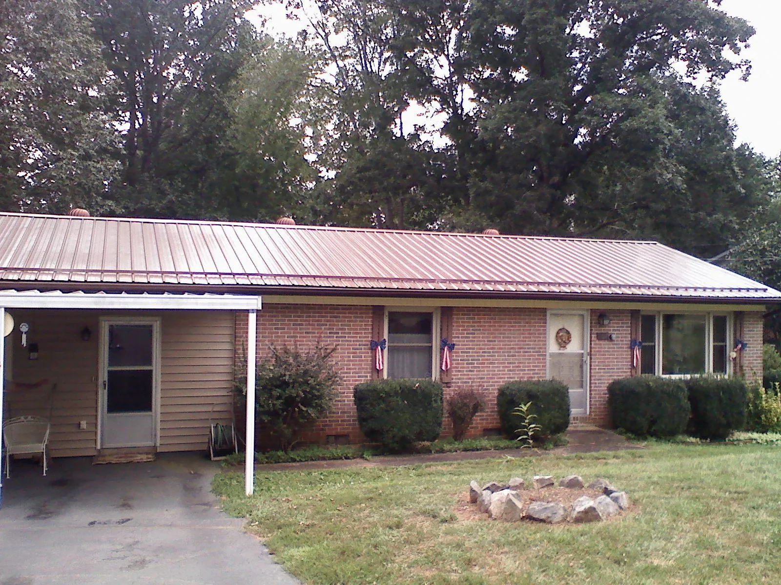 Bronze metal roof and carport on a brick ranch home — Roof Repair work by our crew in Auburntown