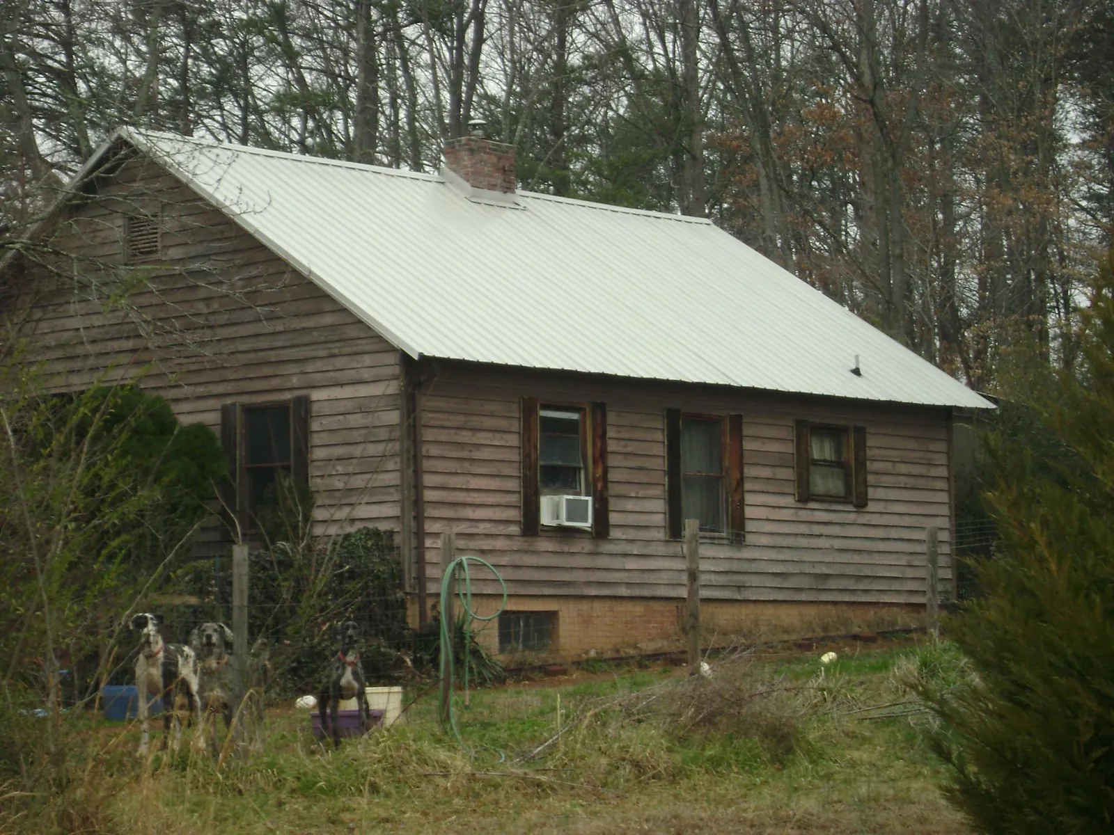 White metal roof on an old wood sided farmhouse, from a Metal Roof Installation job in Auburntown